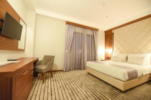 a hotel room with a bed and a desk and a television at Hotel Union in Podgorica