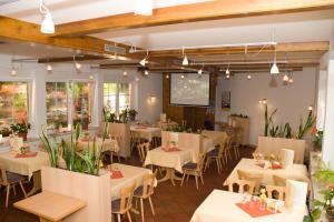 ein Restaurant mit Tischen und Stühlen in einem Zimmer in der Unterkunft Hotel & Restaurant Zur Weintraube in Jena