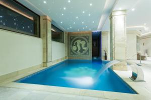 ein Schwimmbad in einem Gebäude mit blauem Boden in der Unterkunft Hotel Helen in Bacău