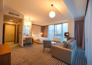 a hotel room with a couch and a bed at Hotel Union in Podgorica