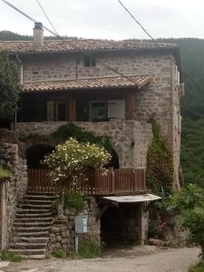 a stone house with a staircase in front of it at L échappée belle in Laviolle