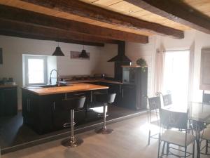 a kitchen with a counter and chairs in a room at L échappée belle in Laviolle