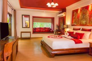 a bedroom with a large bed and a television at E-outfitting Boutique Chiang Mai in Chiang Mai