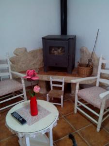 a living room with a fireplace and a table and chairs at Hansel y Gretel in Pedrosa del Rey