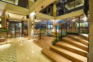 a lobby of a building with stairs and tables and chairs at Hotel Union in Podgorica