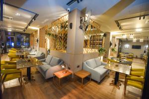 a restaurant with couches and tables and chairs at Hotel Union in Podgorica