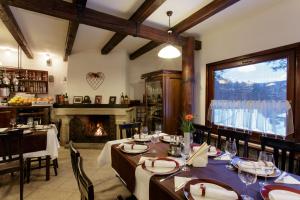 a dining room with a table and a fireplace at Hotel Helen in Bacău