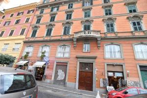 un edificio naranja en una calle con coches aparcados delante en LATERANO 250 - COLOSSEO, en Roma