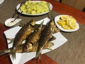 a plate of fish on a table with plates of fruit at Casa Lenuta in Mila Douăzeci şi Trei +10 photos