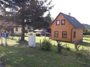 una pequeña casa de madera en un patio con un árbol en Chata Thurmberg, en Vyšší Brod