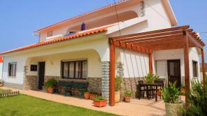 a white house with a patio and a table at Moradia O Pinhal, S. Lourenço - Ericeira in Casais de São Lourenço