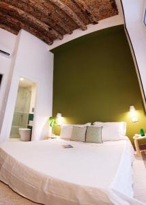 ein Schlafzimmer mit einem großen weißen Bett und einer grünen Wand in der Unterkunft BB Casamatta in Neapel