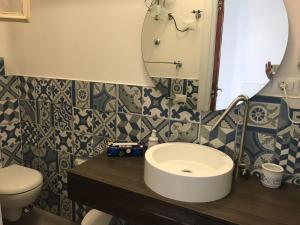 W łazience znajduje się umywalka, toaleta i lustro. w obiekcie Le Sabbie Nere w mieście Vulcano