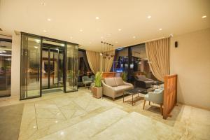 a lobby with chairs and tables and windows at Hotel Union in Podgorica