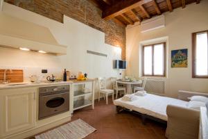 a kitchen and a living room with a bed and a table at Ognissanti apartment in Florence