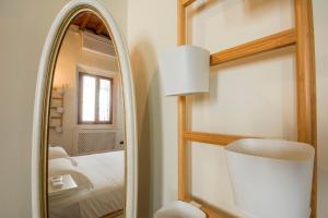 een slaapkamer met een spiegel, een lamp en een bed bij Ognissanti apartment in Florence