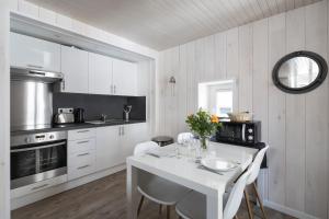 eine weiße Küche mit einem weißen Tisch und Stühlen in der Unterkunft Le Hublot by Cocoonr in Saint-Malo