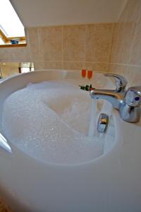 bañera llena de agua con grifo en Sebay Mill Holiday Apartments, en Toab