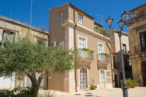 a building with a tree in front of it at Le tre muse in Siracusa