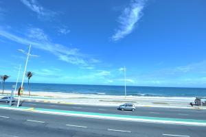 a car driving down a road next to the beach at Rede Andrade Plaza Salvador in Salvador