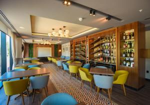 a restaurant with wooden tables and yellow chairs at Hotel Union in Podgorica