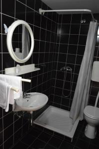 uma casa de banho com um lavatório, um WC e um espelho. em Gostilna s prenocisci Danica em Slovenska Bistrica