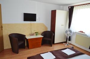 a bedroom with a desk and two chairs and a television at Gostilna s prenocisci Danica in Slovenska Bistrica