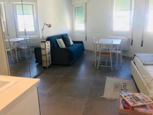 een woonkamer met een blauwe bank en een tafel bij appartamento piazza mazzini in Lido di Jesolo