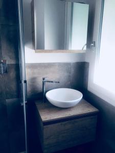 een badkamer met een witte wastafel en een spiegel bij appartamento piazza mazzini in Lido di Jesolo