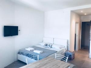 een slaapkamer met een bed en een tafel en een televisie bij appartamento piazza mazzini in Lido di Jesolo