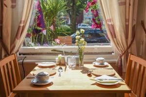 a wooden table with plates and utensils in front of a window at Shearwater in Bridlington