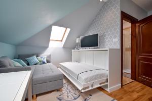 a living room with a couch and a tv at Apartament Baltic Star Rewal in Rewal