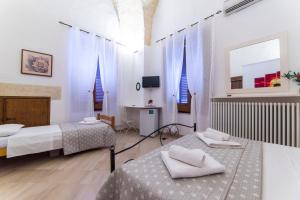 1 dormitorio con 2 camas y escritorio. en B&B La Campana Salentina, en Galatone