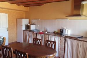 a kitchen with a table and a refrigerator at Casa del Bueno in Peralta de la Sal