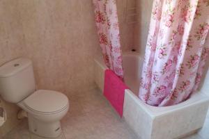 a bathroom with a toilet and a shower curtain at Casa del Bueno in Peralta de la Sal