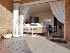 ein Schlafzimmer mit einem Bett und einem großen Fenster in der Unterkunft Pearly Sands in Pearly Beach