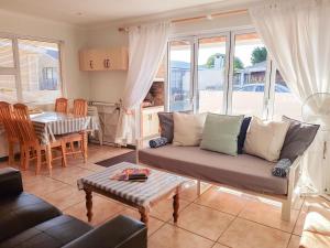 ein Wohnzimmer mit einem Sofa und einem Tisch in der Unterkunft Pearly Sands in Pearly Beach