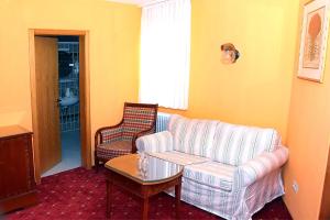 ein Wohnzimmer mit einem Sofa und einem Tisch in der Unterkunft Hotel Neustädter Hof in Titisee-Neustadt