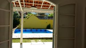 otwarte drzwi prowadzące do basenu przez dom w obiekcie Casa da Yolanda - Hospedaria w mieście São Francisco Xavier