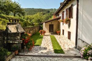 una pasarela de piedra que conduce a una casa con flores en Guest House Most, en Buzet