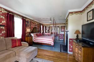 a living room with a couch and a tv at The Reynolds Mansion in Asheville +27 photos