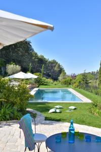 une terrasse avec une table et des chaises ainsi qu'une piscine dans l'établissement Mas du Perthus, à Cassis