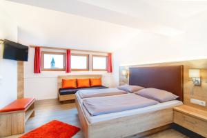 1 Schlafzimmer mit 2 Betten und orangefarbenen Kissen in der Unterkunft Hotel Sonnenheim in Sterzing