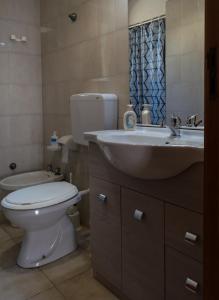 a bathroom with a white toilet and a sink at Casa Volcanalia in Vulcano +34 photos