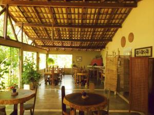 un restaurant avec des tables et des chaises et un plafond en bois dans l'établissement Pousada Éden, à Sao Jorge