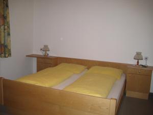 een slaapkamer met 2 bedden met gele lakens bij Haus Kaiser in Passriach