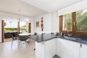 Una cocina con gabinetes blancos y una mesa con sillas. en Picara, en Mancor del Valle