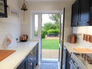 a kitchen with blue cabinets and a view of a yard at Menhyr in Carbis Bay