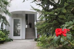 a white house with a red flower in front of it at Villa Giulia in Grado