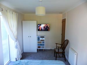 a bedroom with a bed and a tv on the wall at Menhyr in Carbis Bay